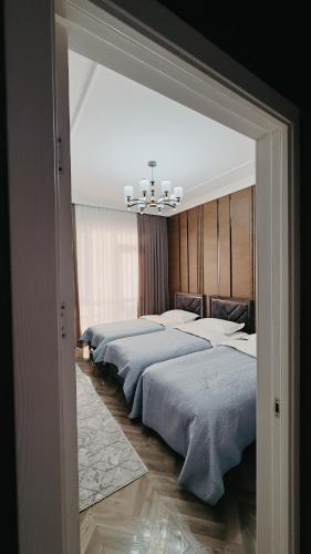 ein Schlafzimmer mit zwei Betten und einem Kronleuchter in der Unterkunft Жк Керуен Сарай in Türkistan
