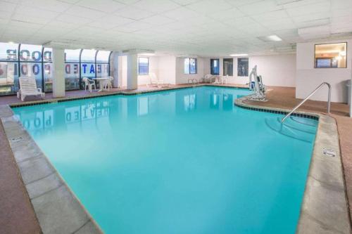 une grande piscine avec de l'eau bleue dans une chambre d'hôtel dans l'établissement Super 8 By Wyndham Garland North Dallas Area, à White Rock