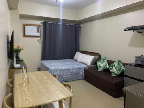 a small living room with a bed and a couch at CDO City Center Avida Condo Fast Wifi in Cagayan de Oro