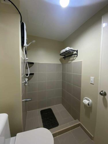 a bathroom with a shower and a toilet at CDO City Center Avida Condo Fast Wifi in Cagayan de Oro