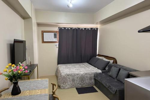 een woonkamer met een bank en een tv bij CDO City Center Avida Condo Fast Wifi in Cagayan de Oro