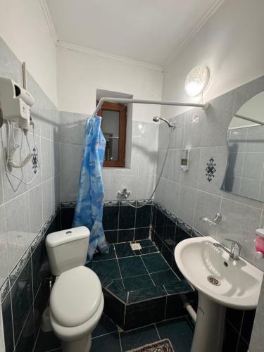 ein Badezimmer mit Toilette und Waschbecken in der Unterkunft Жайсан in Karakol