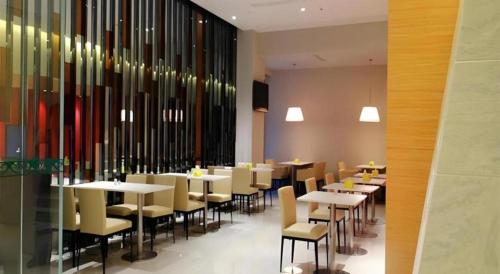 a dining room with tables and chairs in a restaurant at Jinjiang Inn Sanya Jiefang Road Tax Free Shopping Center in Sanya