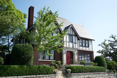 a house with a red door and bushes at Bluff View Inn in Chattanooga