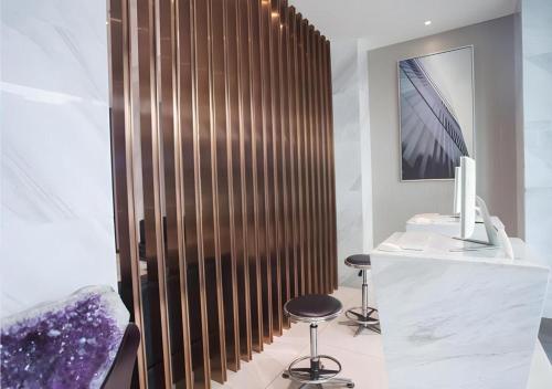 une salle de bain avec un mur en bois avec deux tabourets dans l'établissement City Comfort Inn Zhanjiang Shimao Building Chikan Old Street, à Tchia-k'am