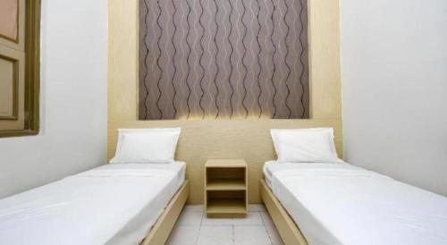 zwei Betten nebeneinander in einem Zimmer in der Unterkunft Super OYO 2436 Hotel Kencana in Tegal