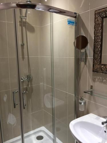 a shower with a glass door next to a sink at Vista Mar in Tarrafal