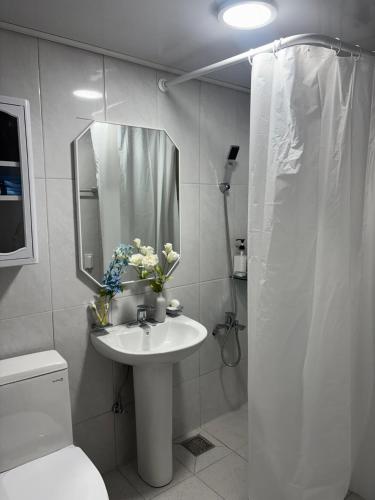 a white bathroom with a sink and a mirror at 러너리 스테이 in Seoul