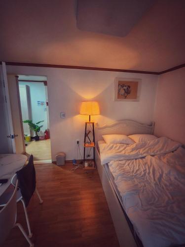 a bedroom with a large bed and a lamp at 러너리 스테이 in Seoul