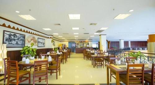 a restaurant with wooden tables and chairs and a cafeteria at Vientiane Plaza Hotel in Vientiane