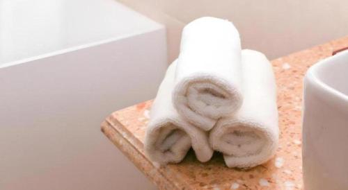 ein Stapel Handtücher auf einer Ablage im Badezimmer in der Unterkunft Mika Hotel in Ulaanbaatar