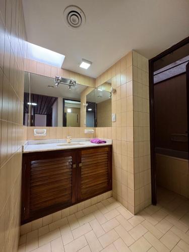 a bathroom with a sink and a large mirror at Casa Eusebio Blanco con patio parrilla y cochera en el centro de Mendoza in Mendoza