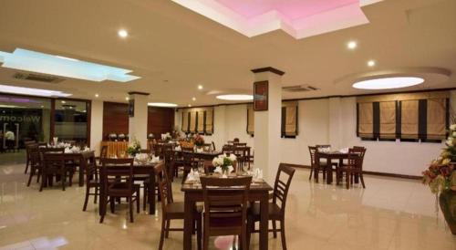 a dining room with tables and chairs in a restaurant at Lao Golden Hotel in Ban That-Louang