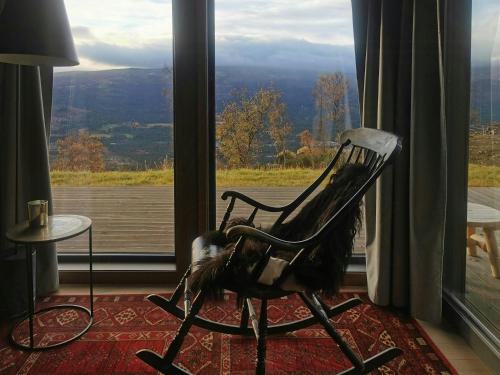 a rocking chair sitting in front of a window at Mountain Cabin With Panoramic Views In Oppdal in Gorset
