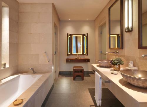 baño con 2 lavabos y bañera grande en Anantara Al Jabal Al Akhdar Resort, en Al ‘Aqar