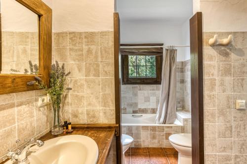 a bathroom with a sink and a toilet and a tub at Casa Bali Costa Brava in Llofríu