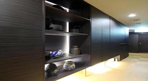 une cuisine avec des murs noirs et des étagères avec des vases dans l'établissement Suigetsurou Hotel, à Tonami