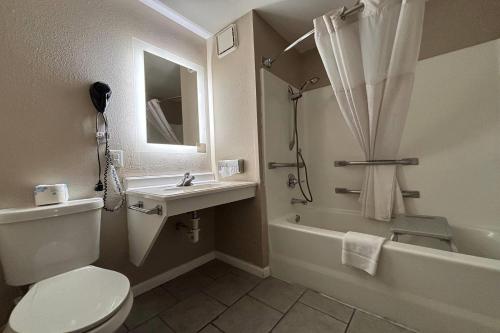 a bathroom with a toilet and a sink and a tub at Super 8 by Wyndham Alton in Alton