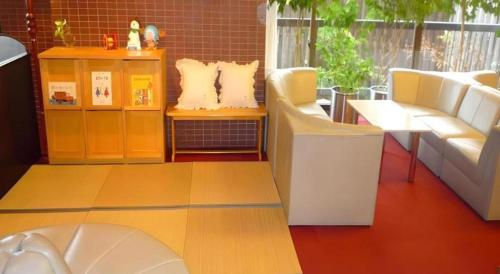 ein Wohnzimmer mit zwei weißen Sofas und einem Tisch in der Unterkunft Hotel Heights in Yamanouchi