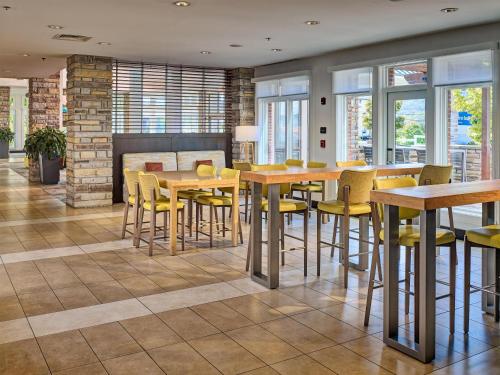 a restaurant with yellow chairs and tables and windows at Hilton Garden Inn Pigeon Forge in Pigeon Forge