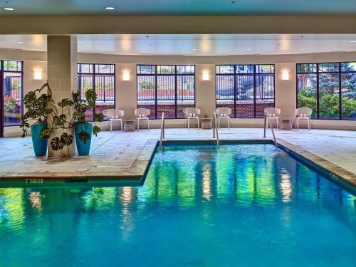 a large pool in a hotel with chairs and tables at Hilton Garden Inn Pigeon Forge in Pigeon Forge