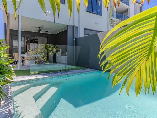 a swimming pool in front of a house at 3 Bed Beach Retreat with Pool 1 min walk to sand in Kingscliff