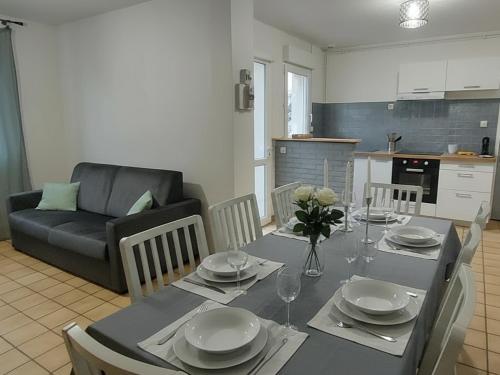 a dining room with a table and a couch at Le Georges Durand - Parking - 5 min du Circuit 24H - Wifi - 2 chambres in Le Mans