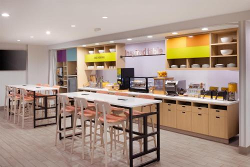 un restaurant avec des tables et des chaises dans une cuisine dans l'établissement Home 2 Suites By Hilton Jackson, à Jackson