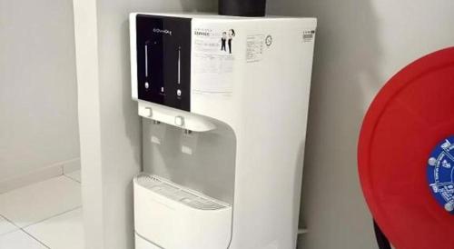 a water dispenser on a wall next to a red object at Pendang Suite Hotel PLT in Pendang