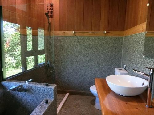 a bathroom with a white sink and a toilet at Sun Moon Home in Yuchi