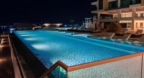 a swimming pool at night with chairs and a building at Seafest Hotel Semporna in Semporna