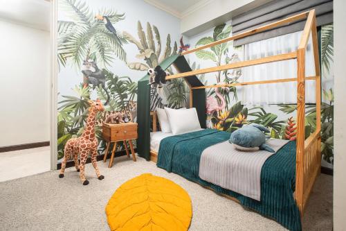 a bedroom with a bed with a giraffe and other stuffed animals at Aryaduta Suite Semanggi in Jakarta