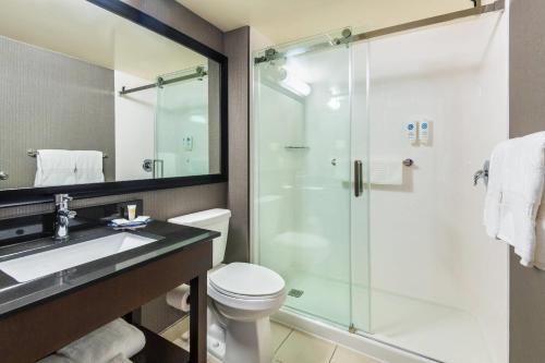 une salle de bains avec douche, toilettes et lavabo dans l'établissement Comfort Inn Hwy 401, à Kingston