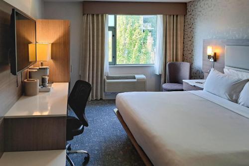 a hotel room with a bed and a desk and a window at Comfort Hotel Vancouver Airport in Richmond