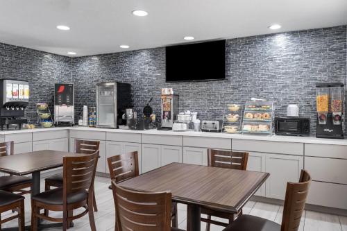 a restaurant with two tables and a bar with a tv at Travelodge by Wyndham Fargo in Fargo