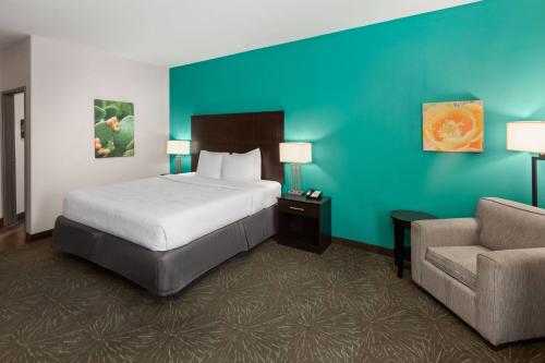 a hotel room with a bed and a chair at Baymont by Wyndham Andrews TX in Andrews