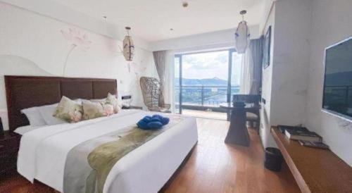 a bedroom with a large bed and a large window at Wyndham Garden Hotel in Lingshui