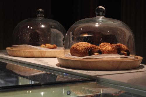 Dos platos de comida en cúpulas de cristal sobre una mesa en Maxwell Reserve Singapore, Autograph Collection, en Singapur