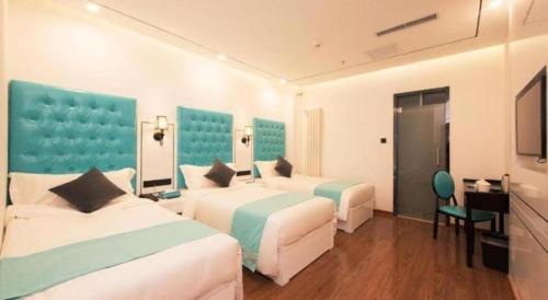 Cette chambre comprend 3 lits et un bureau. dans l'établissement Xana Lite Beijing West Station Branch, à Pékin