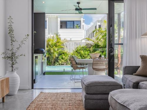 a living room with a table and chairs at 3 Bed Beach Retreat with Pool 1 min walk to sand in Kingscliff