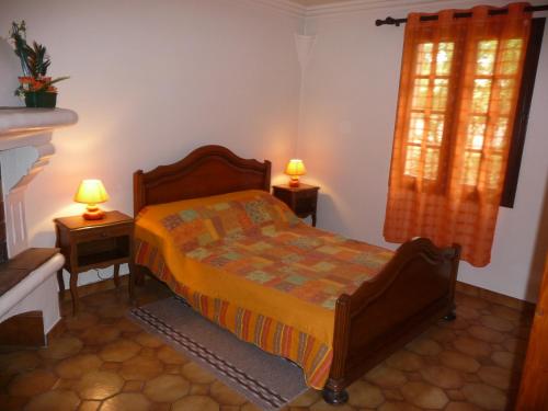 a bedroom with a bed and two lamps on tables at Le coin tranquille in Vidauban