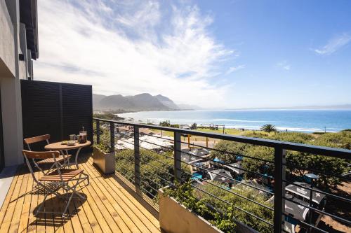 a balcony with a table and a view of the beach at Oceanfront Duplex Apartments, Hermanus Waterfront in Hermanus