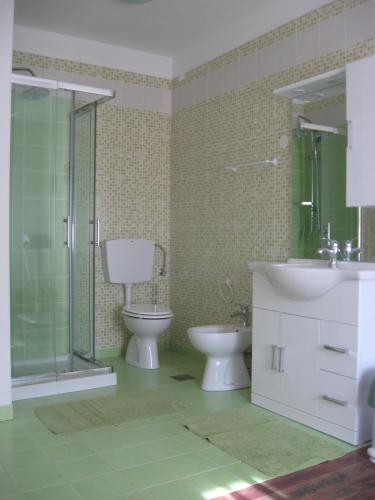 a bathroom with a toilet and a sink and a shower at Country House Lokev in Lokev