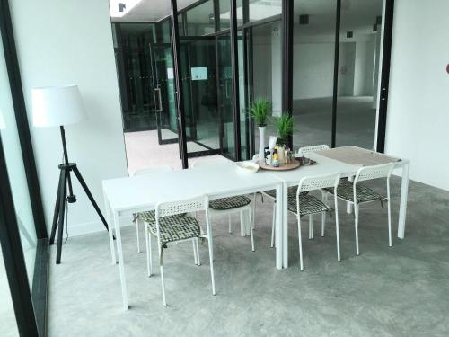 a white table and chairs in a room with a lamp at A-Port in Lat Krabang