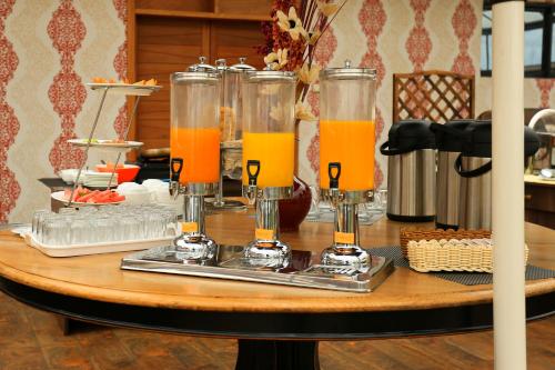 a table with glasses of orange juice on it at Lotos Inn & Suites, Nairobi in Nairobi