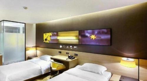 a hotel room with two beds and a desk at IU Hotels·Anshun Nanma Square in Anshun
