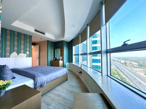 a bedroom with a bed and a large window at Centaurus mall two bed apartment in Islamabad