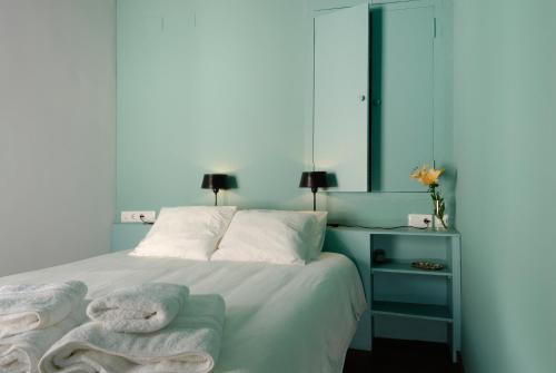 a bedroom with a bed with towels on it at Apartamentos La Hoguera in Córdoba