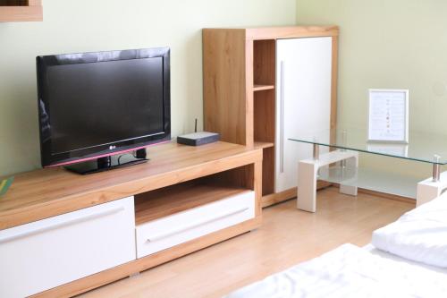 ein Wohnzimmer mit einem Flachbild-TV auf einem hölzernen Entertainment-Center in der Unterkunft Apartment Favoritenstraße in Wien