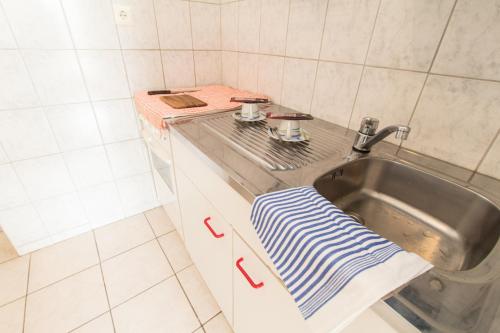 eine Küchenspüle mit einem blau und weiß gestreiften Handtuch in der Unterkunft Apartment Favoritenstraße in Wien